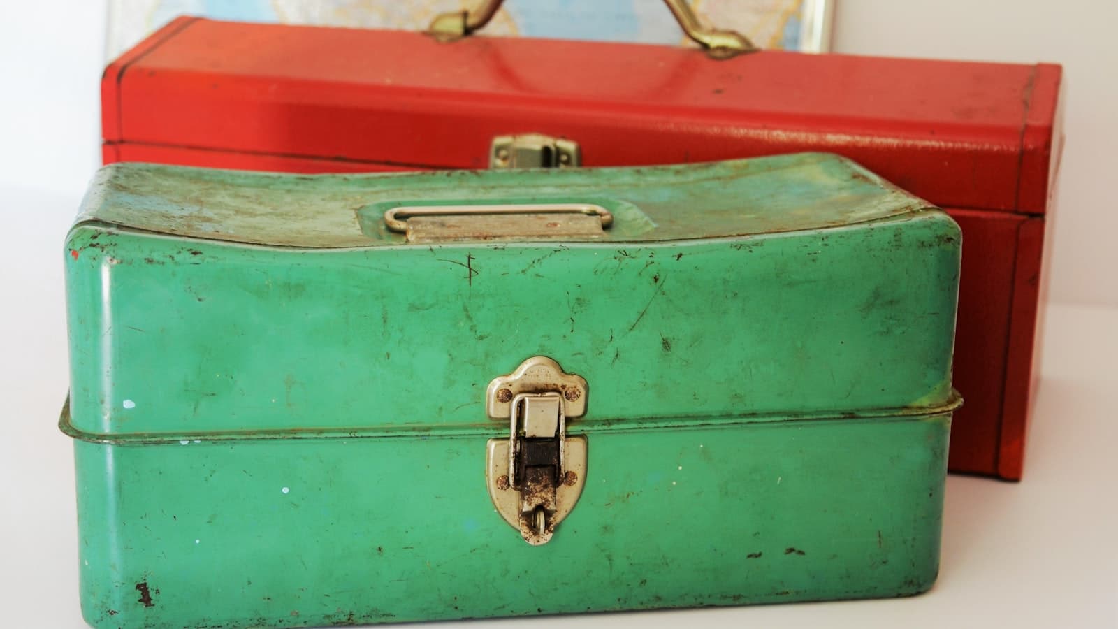 Editorial photograph of an open vintage leather toolbox on a workshop bench, with brass wrenches and modern tools arranged inside.
